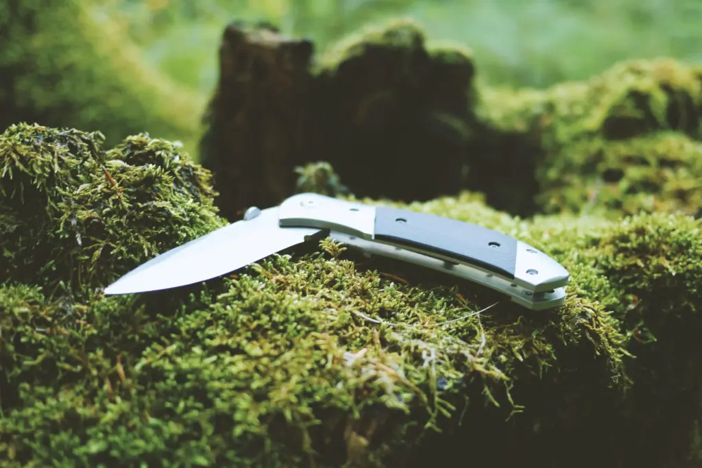 Ausrüstung: Outdoor-Messer liegt auf Holz – praktisches Werkzeug für draußen
