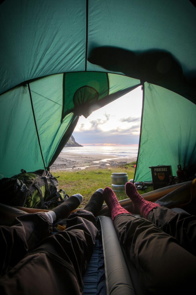 Aussicht aus dem Inneren eines Zelts beim Camping in Süddeutschland mit Blick auf Berge und Natur
