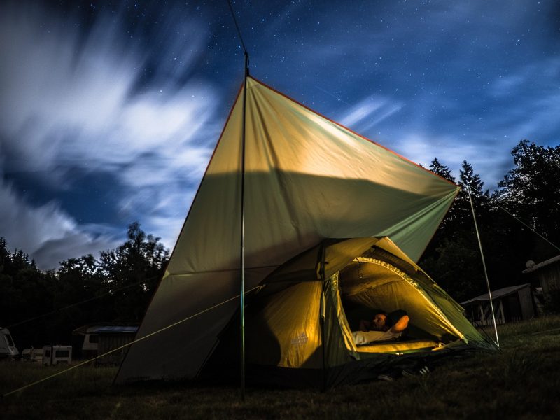 Zelt beim Sommercamping auf Wiese mit Sonne und Natur