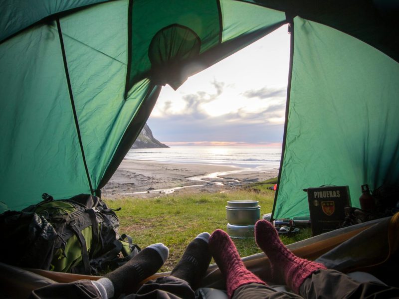 Aussicht aus dem Inneren eines Zelts beim Camping in Süddeutschland mit Blick auf Berge und Natur